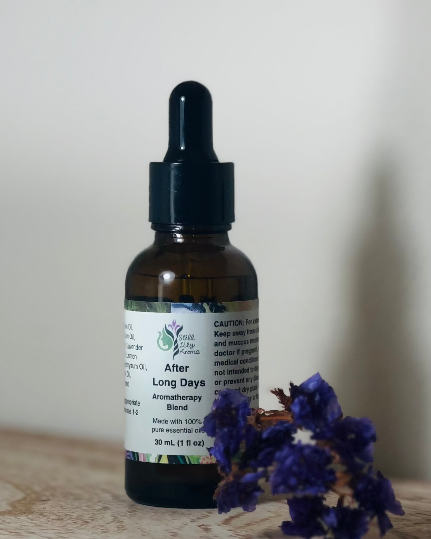 Bottle of 'After Long Days' aromatherapy blend with a dropper on a wooden surface.
