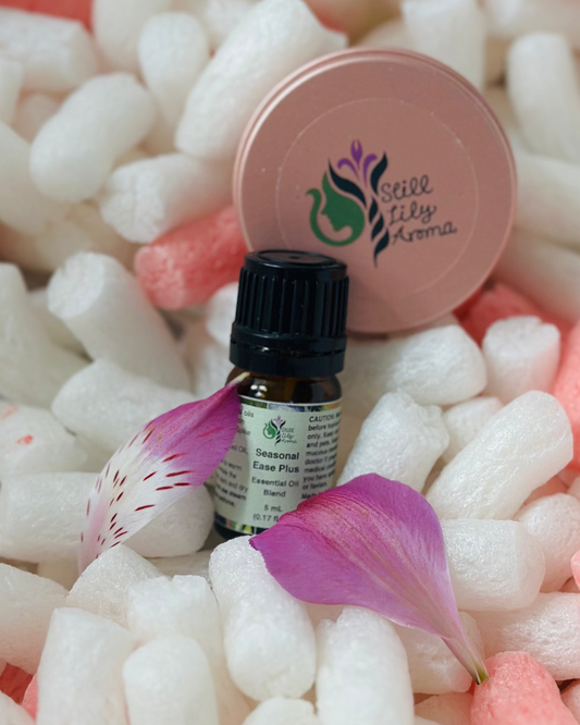 Small bottle of Seasonal Ease Plus essential oil on a bed of white packing peanuts.